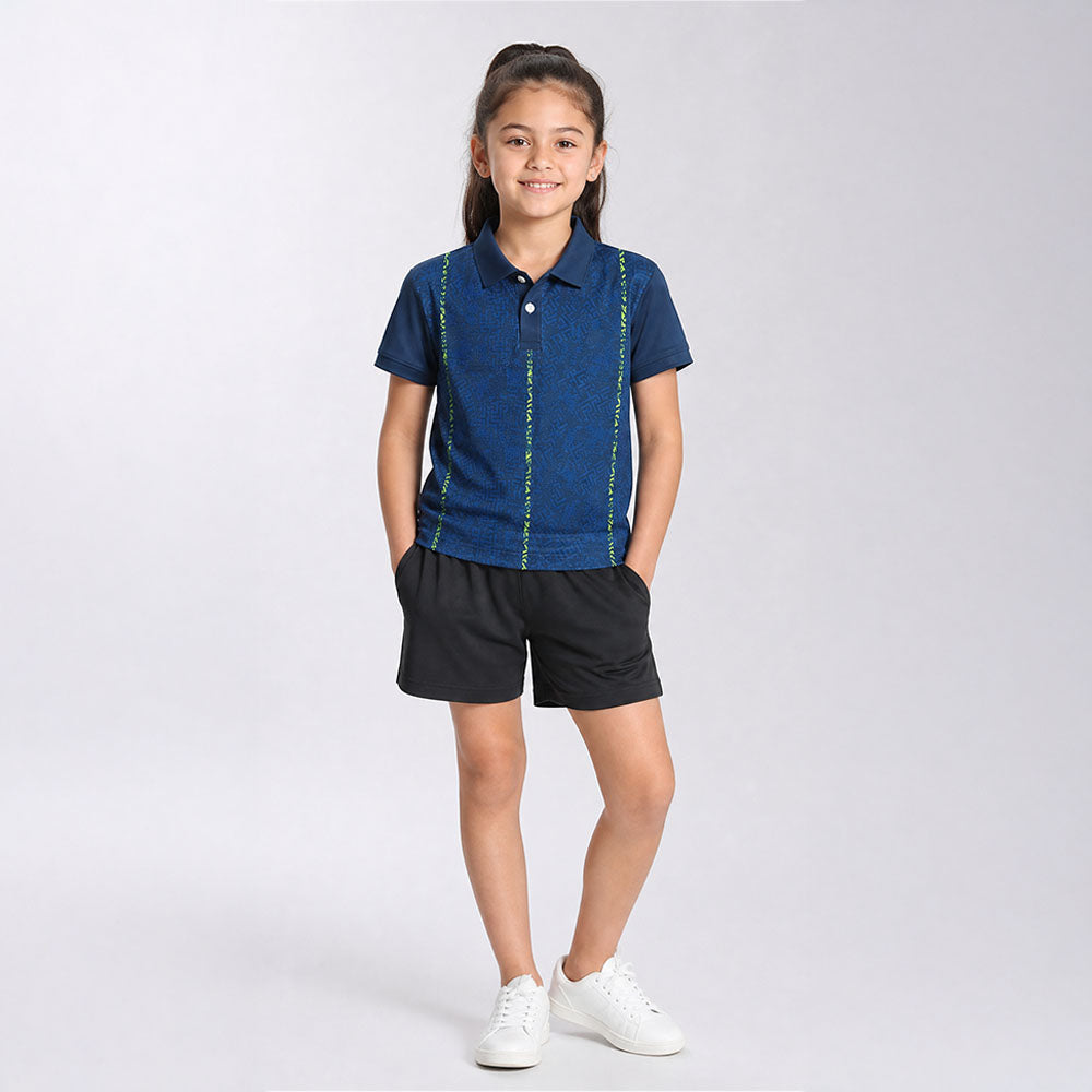Kids' polo sports jersey in navy blue with lime vertical accents, worn by a child in black shorts standing in a studio.
