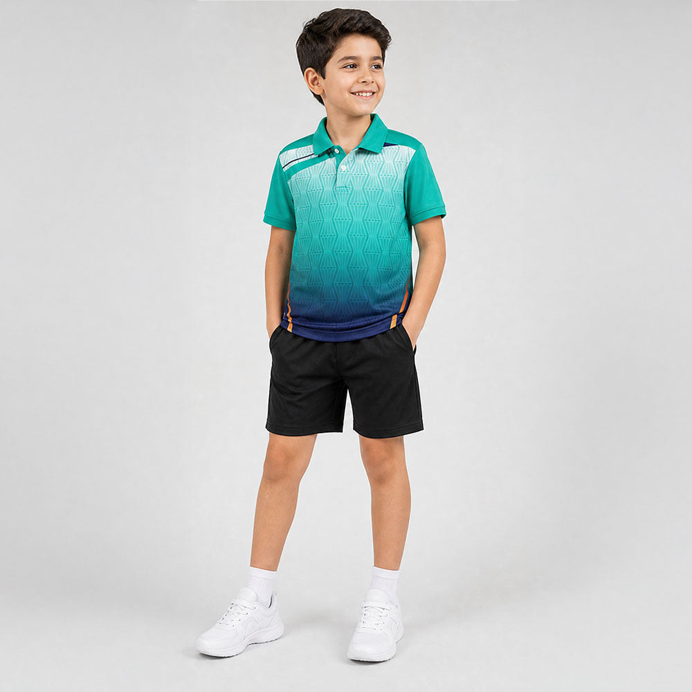 Kids' polo sports jersey in teal and navy gradient with white geometric accents, worn by a child in black shorts standing in a studio.