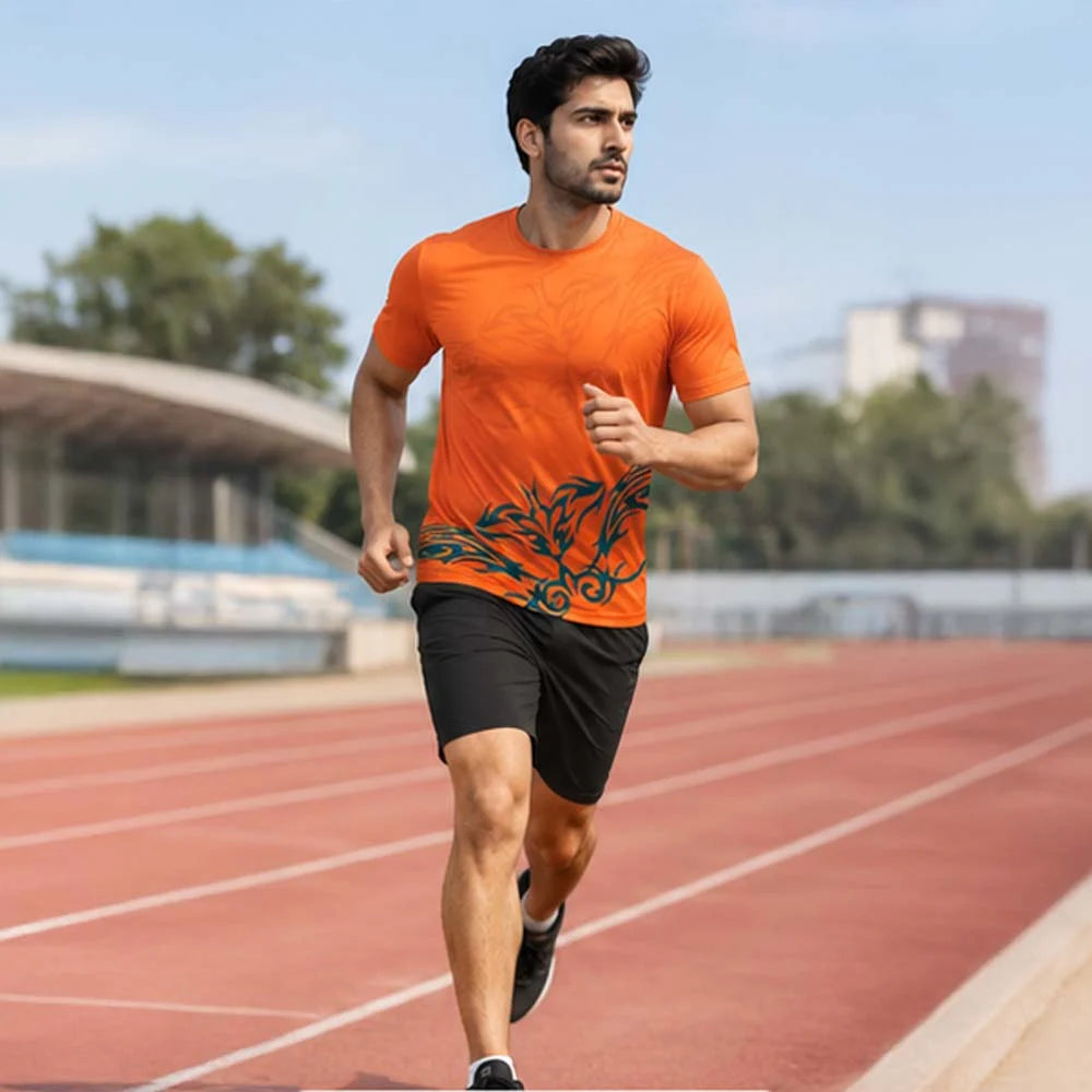 Man running on an athletics track wearing an orange round-neck jersey with teal leaf motif and black shorts