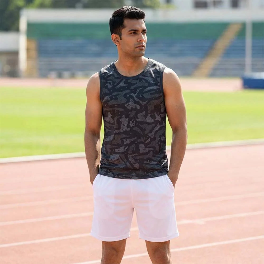 Model wearing charcoal camouflage singlet and white shorts at an outdoor sports ground