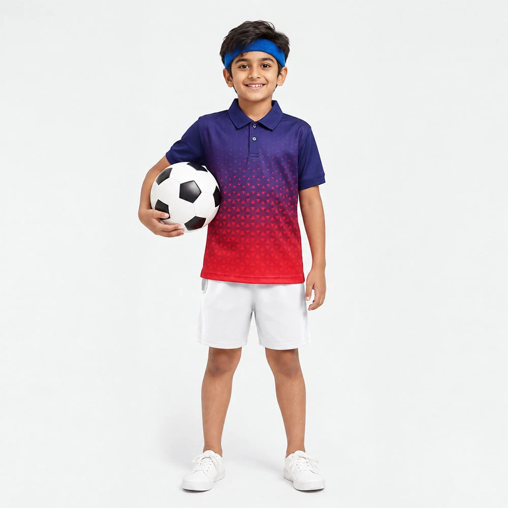 Child wearing a navy-to-red dotted gradient polo jersey and white shorts, holding a football.