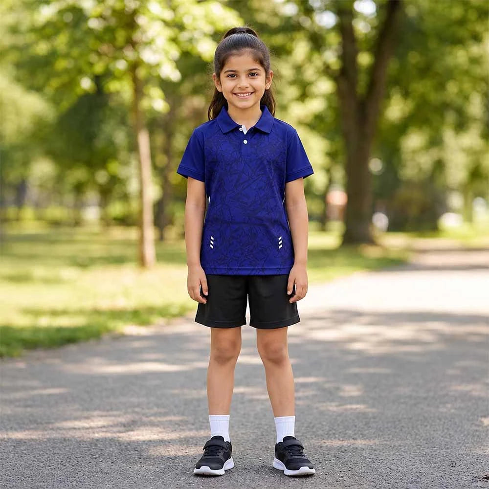 Child wearing a navy with a tonal angular pattern polo jersey and black shorts, standing outdoors.