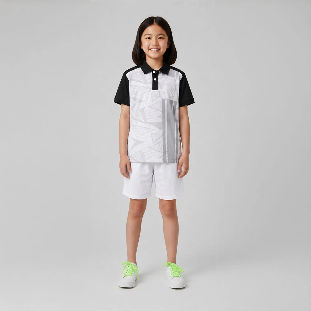 Child wearing the white and grey geometric graphics with black sleeves polo jersey with white shorts, standing in a studio.