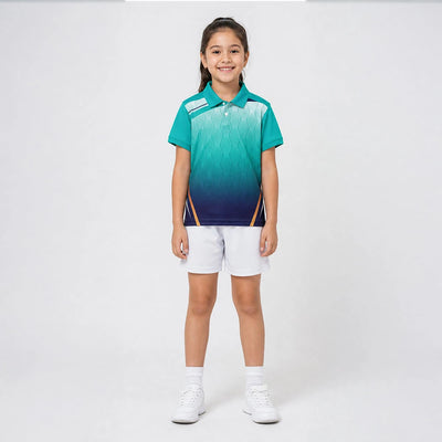 Child wearing the teal-to-navy gradient with geometric detail polo jersey with white shorts, standing in a studio.